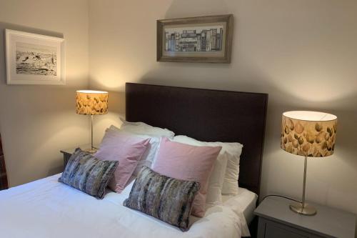 ein Schlafzimmer mit einem Bett mit Kissen und zwei Lampen in der Unterkunft Bright Modern Apartment - Royal Mile in Edinburgh