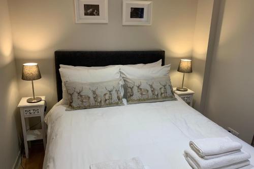 una camera con un letto bianco e 2 lampade di Bright Modern Apartment - Royal Mile a Edimburgo