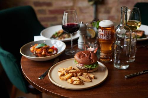 a table with plates of food and glasses of beer at The Kings Arms in Woodstock