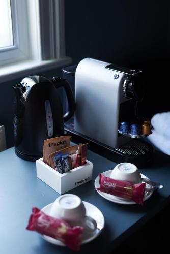 a table with a coffee maker and tea packets at The Kings Arms in Woodstock