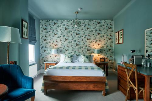 um quarto com uma cama e uma parede azul em The Kings Arms em Woodstock