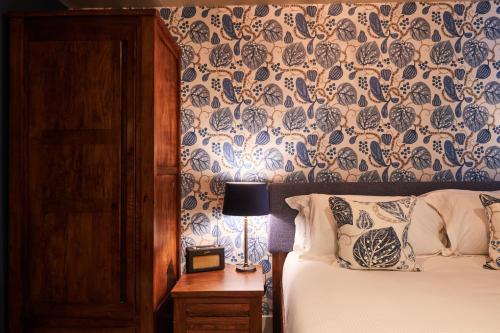 a bedroom with a bed with a blue and white wallpaper at The Kings Arms in Woodstock