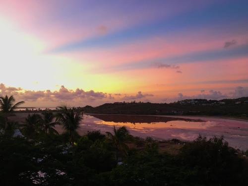 a sunset over a beach with a body of water at Carambola Résidence, Ocean View in Cul de Sac