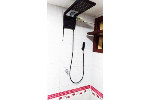 La salle de bains est pourvue d'une douche avec un pommeau de douche noir. dans l'établissement Solar de Pipa Duplex Flat, à Pipa