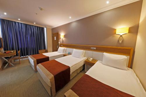 a hotel room with two beds and a desk at Euro Park Hotel Bursa in Bursa