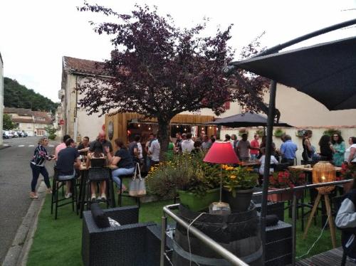 Un groupe de personnes assises à des tables sur l'herbe dans l'établissement Chez l'ahumat, à Aire-sur-lʼAdour