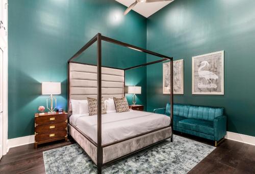 1 dormitorio con cama con dosel y pared azul en The Endymion, en Nueva Orleans