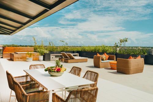 an outdoor patio with a white table and chairs at Domaine de Grand Baie in Grand Baie