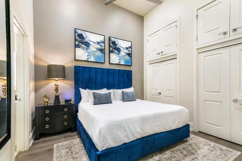 een slaapkamer met een bed met een blauw hoofdeinde bij The Frenchmen in New Orleans
