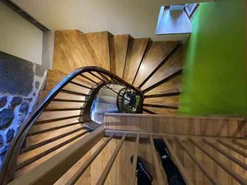 a spiral staircase in a building with a green wall at La Maison - Hôtel & Gîte in Laguiole