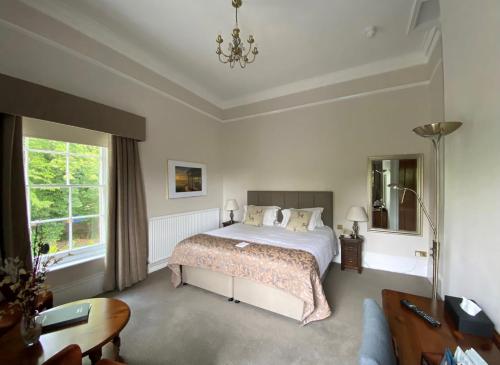 a bedroom with a bed and a table and a couch at Reigate Manor Hotel in Reigate