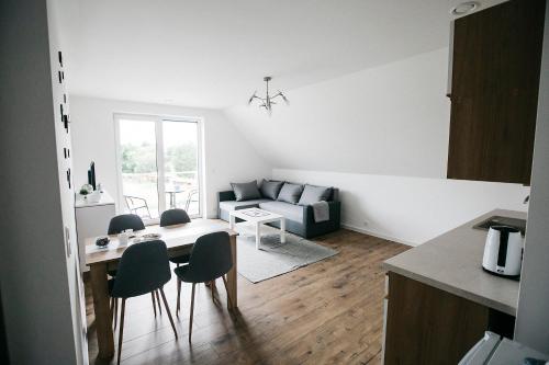 eine Küche und ein Wohnzimmer mit einem Tisch und Stühlen in der Unterkunft Apartamenty Perła Orawy in Zubrzyca Dolna