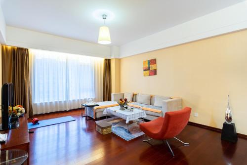 a living room with a couch and a table at Tianjin Crown International Apartment in Tianjin