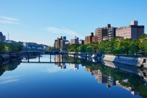a river with a city in the background at EN HOTEL Hiroshima in Hiroshima
