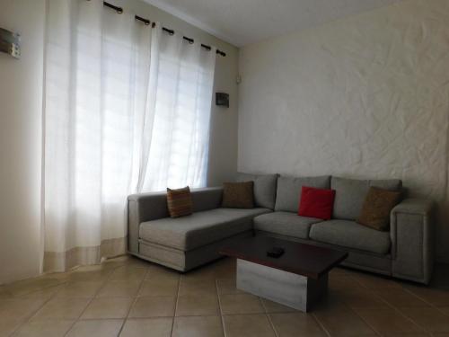 a living room with a couch and a coffee table at Joubarbe Residence in Moka