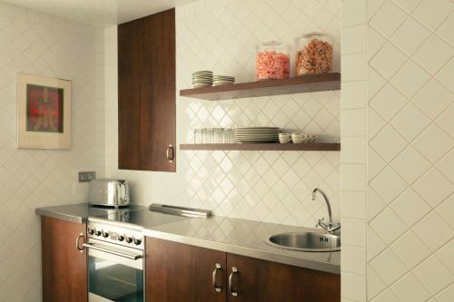 une cuisine avec un évier et une cuisinière dans l'établissement Pied A Terre Saint Honoré, à Paris