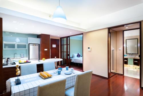 a kitchen and living room with a table and chairs at Tianjin Crown International Apartment in Tianjin