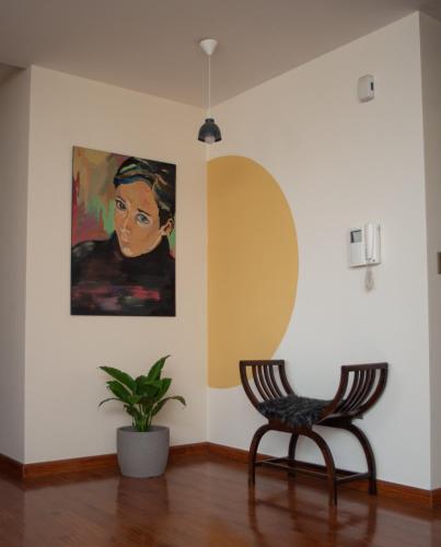 a room with a painting and two chairs and a plant at Apartamento Yellow Gem - Campoverde in Cochabamba