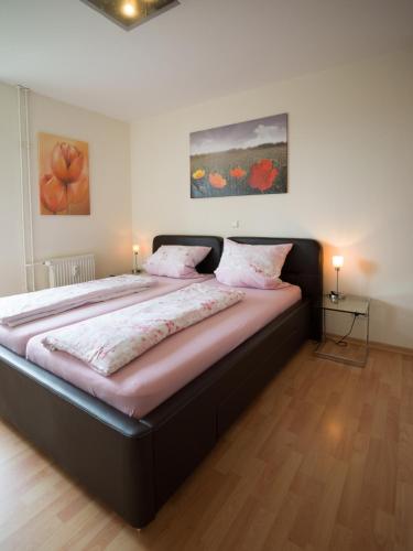 1 cama grande en un dormitorio con 2 lámparas en Ferienwohnung Fernblick en Saarbrücken