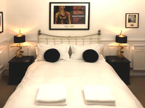 ウィットビーにあるHigh Tor Guest Houseのベッドルーム1室(白いベッド1台、ランプ2つ付)