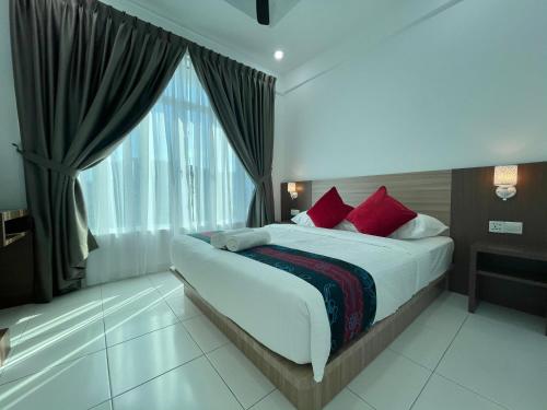 a bedroom with a bed with red pillows and a window at Century Suria Aparment Langkawi by Zervin in Kuah