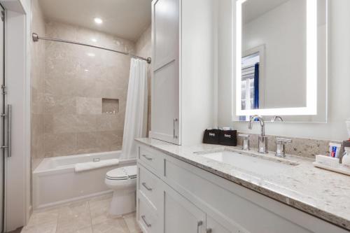 a white bathroom with a sink and a toilet at The Zydeco in New Orleans