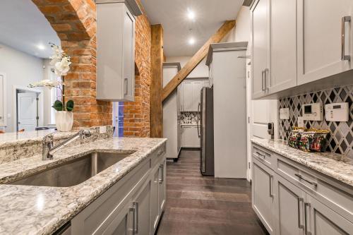 a kitchen with white cabinets and a brick wall at The Jazz in New Orleans