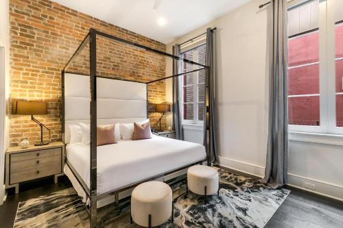 a bedroom with a bed and a brick wall at The Jazz in New Orleans