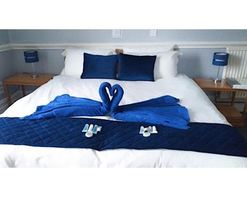 a bed with blue towels and shoes on it at Royal Hotel Sheerness in Sheerness