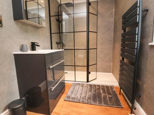 a bathroom with a sink and a glass shower at Retreat By The Bowers in Preston