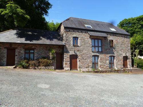 a stone house with brown doors on a street at The Liscawn in Torpoint