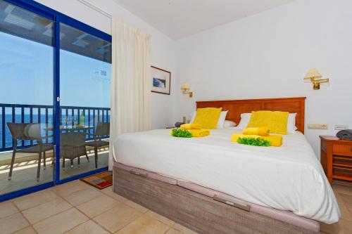 a bedroom with a large bed and a balcony at Brisa Marina in Puerto Calero
