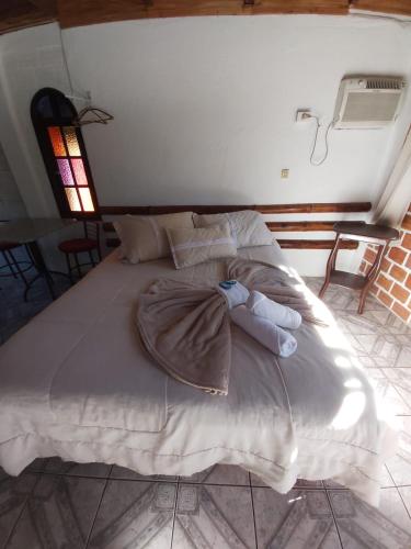 a large bed with a blanket on top of it at Pousada e Restaurante Dona Siroba in Morretes