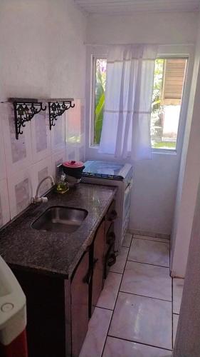 a small kitchen with a sink and a window at Pousada e Restaurante Dona Siroba in Morretes