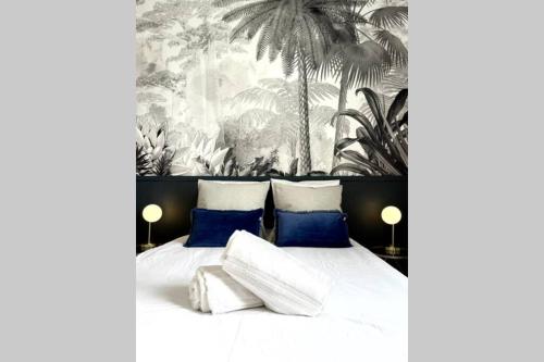 une chambre avec un lit avec des oreillers bleus et blancs dans l'établissement Le Bleu Royal, à Vichy