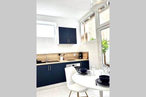 a kitchen with a white table and blue cabinets at Le Bleu Royal in Vichy