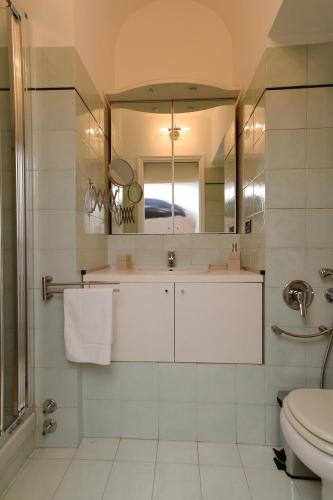 a bathroom with a sink and a toilet and a mirror at Palazzo Graneri in Turin