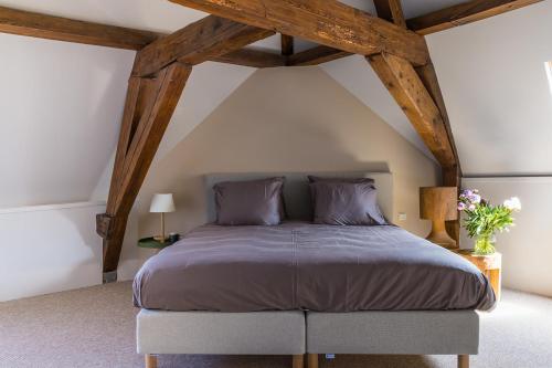 a bedroom with a king sized bed in an attic at Stadshotel Steegoversloot in Dordrecht