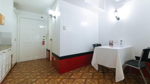 a room with a table and a white table and chairs at RedDoorz at The Providence Tower in Manila