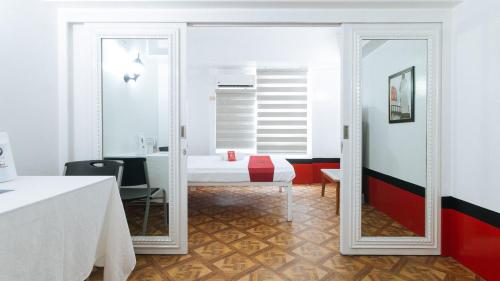 a mirror in a room with a bed and a desk at RedDoorz at The Providence Tower in Manila