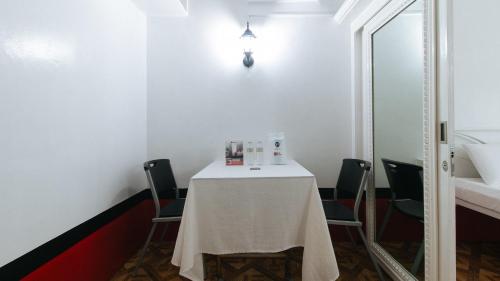 a table in a room with chairs and a mirror at RedDoorz at The Providence Tower in Manila