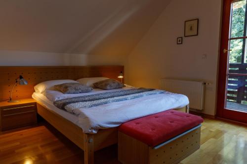1 dormitorio con 1 cama grande y un taburete rojo en Villa Toni, en Bled
