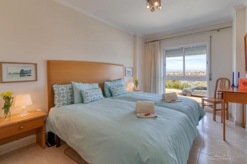 um quarto com uma cama grande com duas toalhas em Pé na Areia praia da Rocha em Portimão