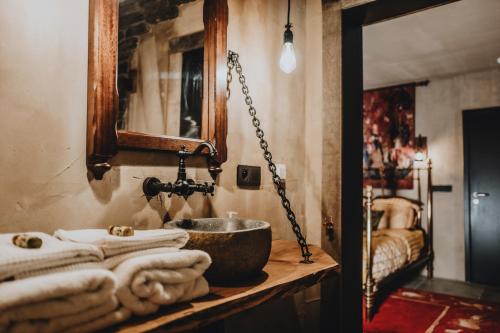 y baño con lavabo y toallas en la encimera. en Le Fantôme de Berthe logement-attraction insolite, en La-Roche-en-Ardenne