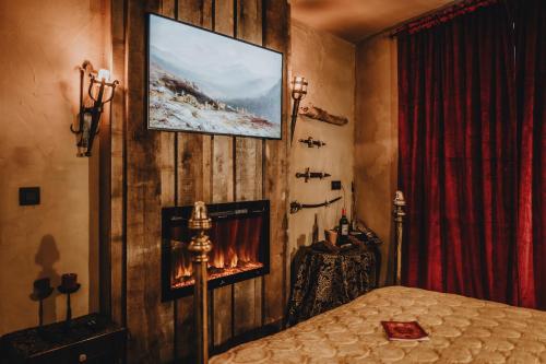 una camera da letto con un letto e una TV a parete di Le Fantôme de Berthe logement-attraction insolite a La-Roche-en-Ardenne