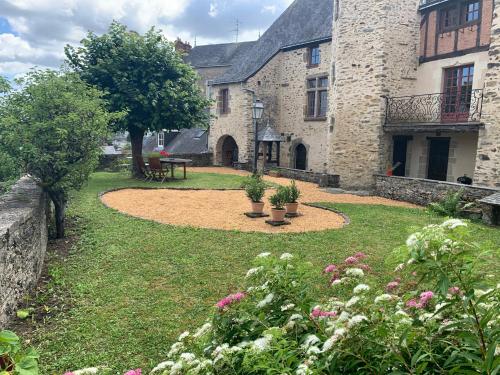 a garden in front of a large stone building at Le logis du Vassal in Laval