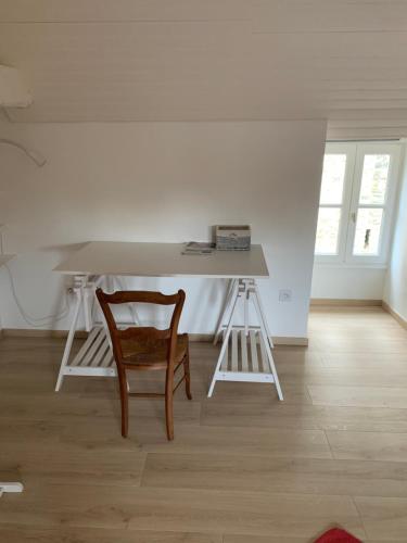 a table and a chair in a room at Le logis du Vassal in Laval