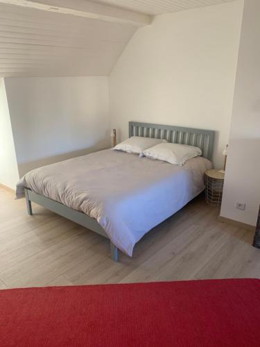 a bedroom with a large bed with a red rug at Le logis du Vassal in Laval