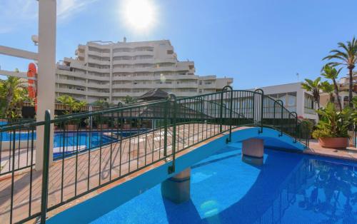 a bridge over a swimming pool with a hotel in the background at Benal Beach Group in Benalmádena