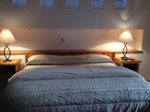 a bedroom with a bed with two lamps on it at La Casona de los Colibríes in Villa del Pueblito